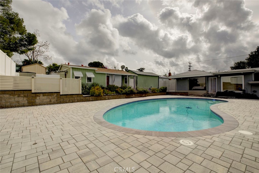 6911 Valmont Street Tujunga, CA 91042 - Photo 36 of 55 a view of a white house with a swimming pool and a yard