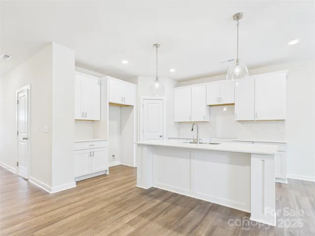 a kitchen with kitchen island white cabinets and stainless steel appliances