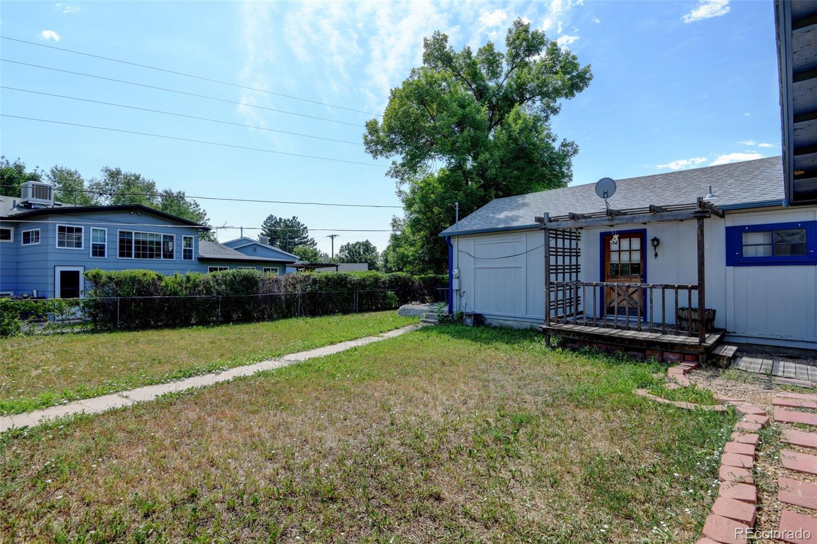 6788 Pierce Way Arvada, CO 80003 - Photo 27 of 28 a view of a backyard with plants and large trees