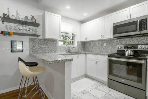 a kitchen with stainless steel appliances granite countertop a stove a sink and a microwave