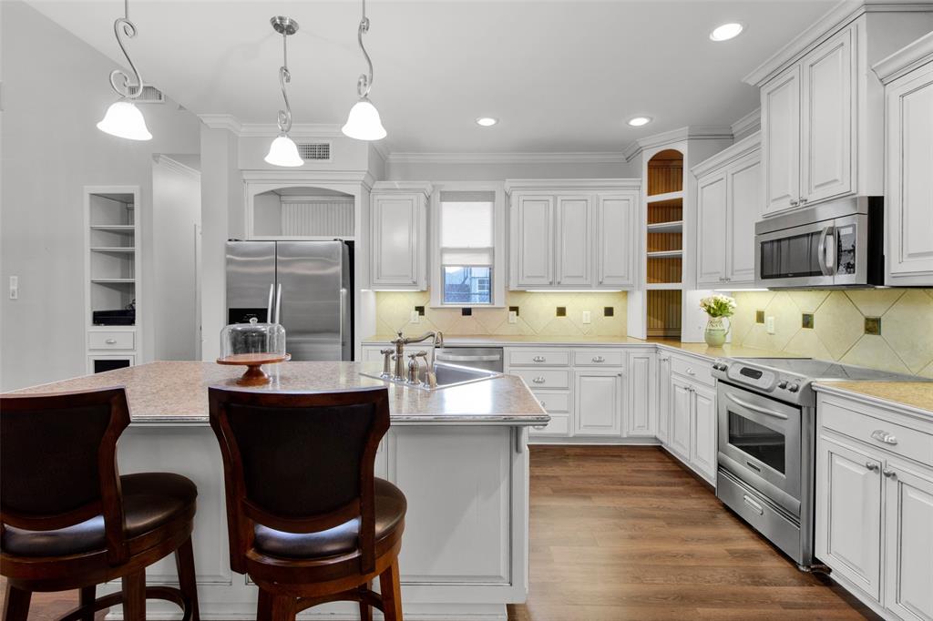 3815 Holly Ridge Drive, Unit GUEST Longview, TX 75605 - Photo 16 of 33 Spacious kitchen featuring an expansive island with a sink, stainless steel appliances, white cabinetry, wood-finish flooring, and recessed lighting