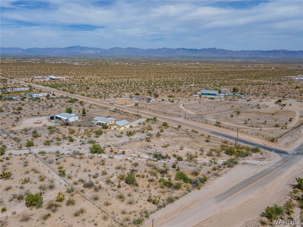 2465 Egar Road Golden Valley, AZ 86413 - Photo 95 of 98 Expansive desert landscape with scattered properties and roads, featuring distant mountains under a partially cloudy sky