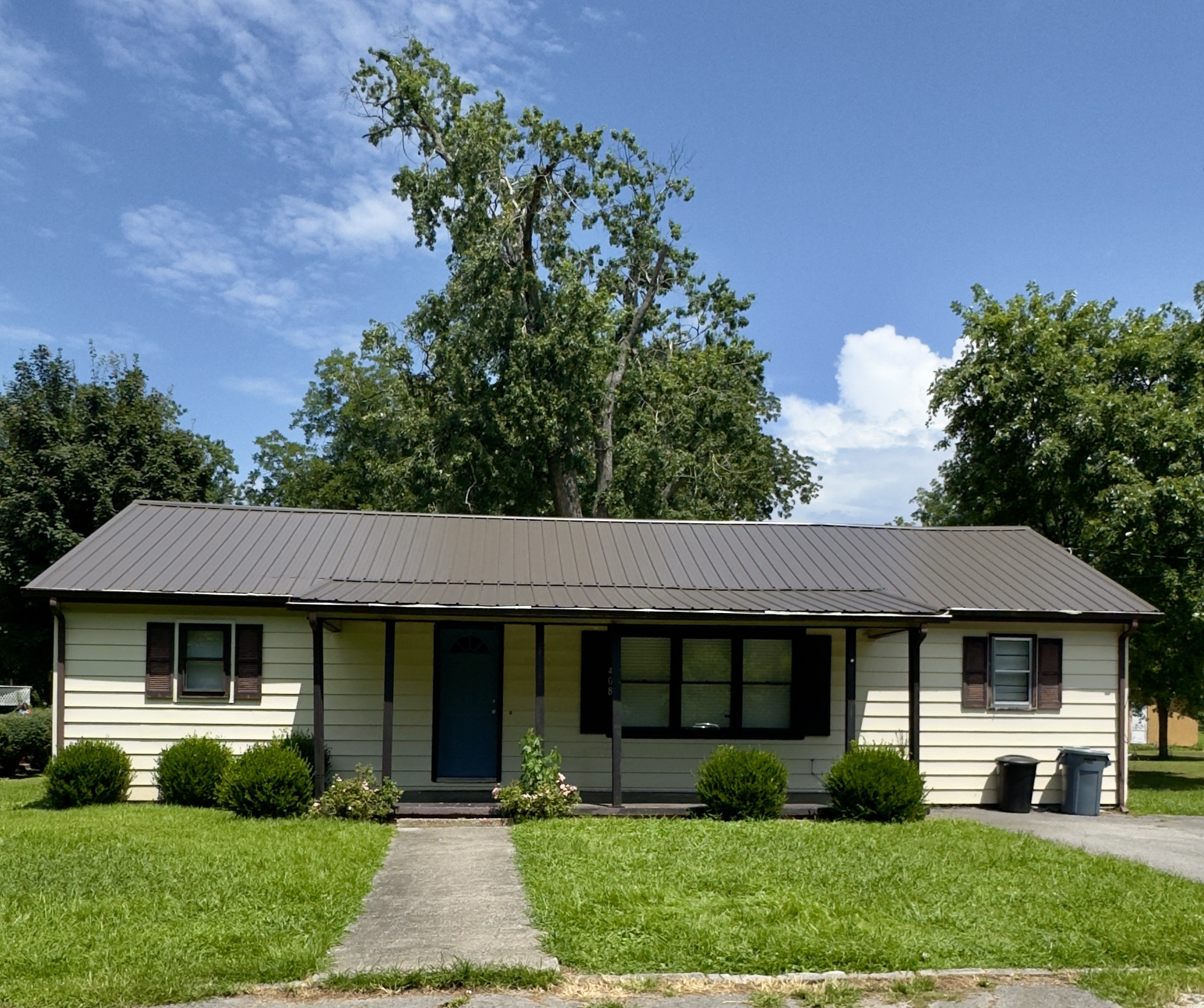 a front view of a house with a garden and plants