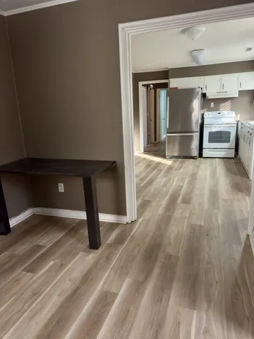 a view of empty room with wooden floor