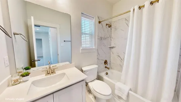 a bathroom with a sink a toilet and shower curtain