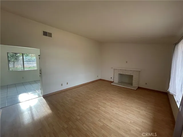 an empty room with a fireplace and window