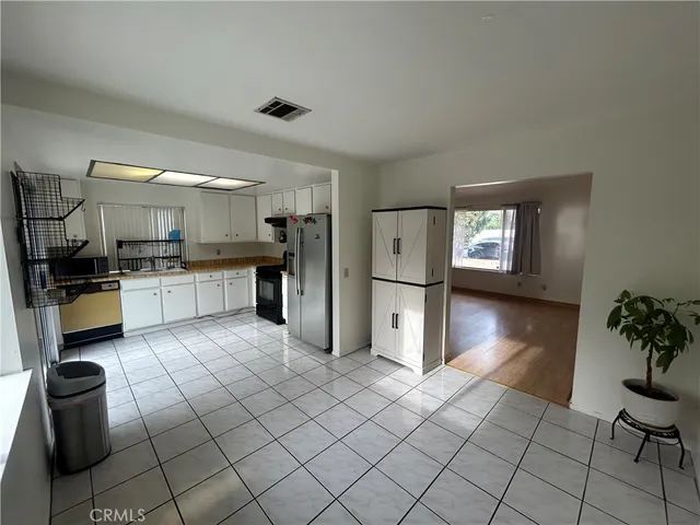 a kitchen with granite countertop a refrigerator and cabinets