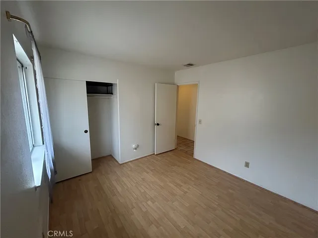 an empty room with wooden floor and entrance