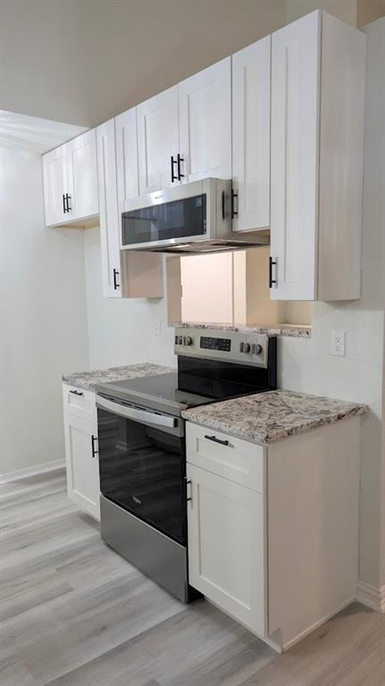 2240 Tarpley Road, Unit 92 Carrollton, TX 75006 - Photo 6 of 17 a kitchen with granite countertop white cabinets and white appliances