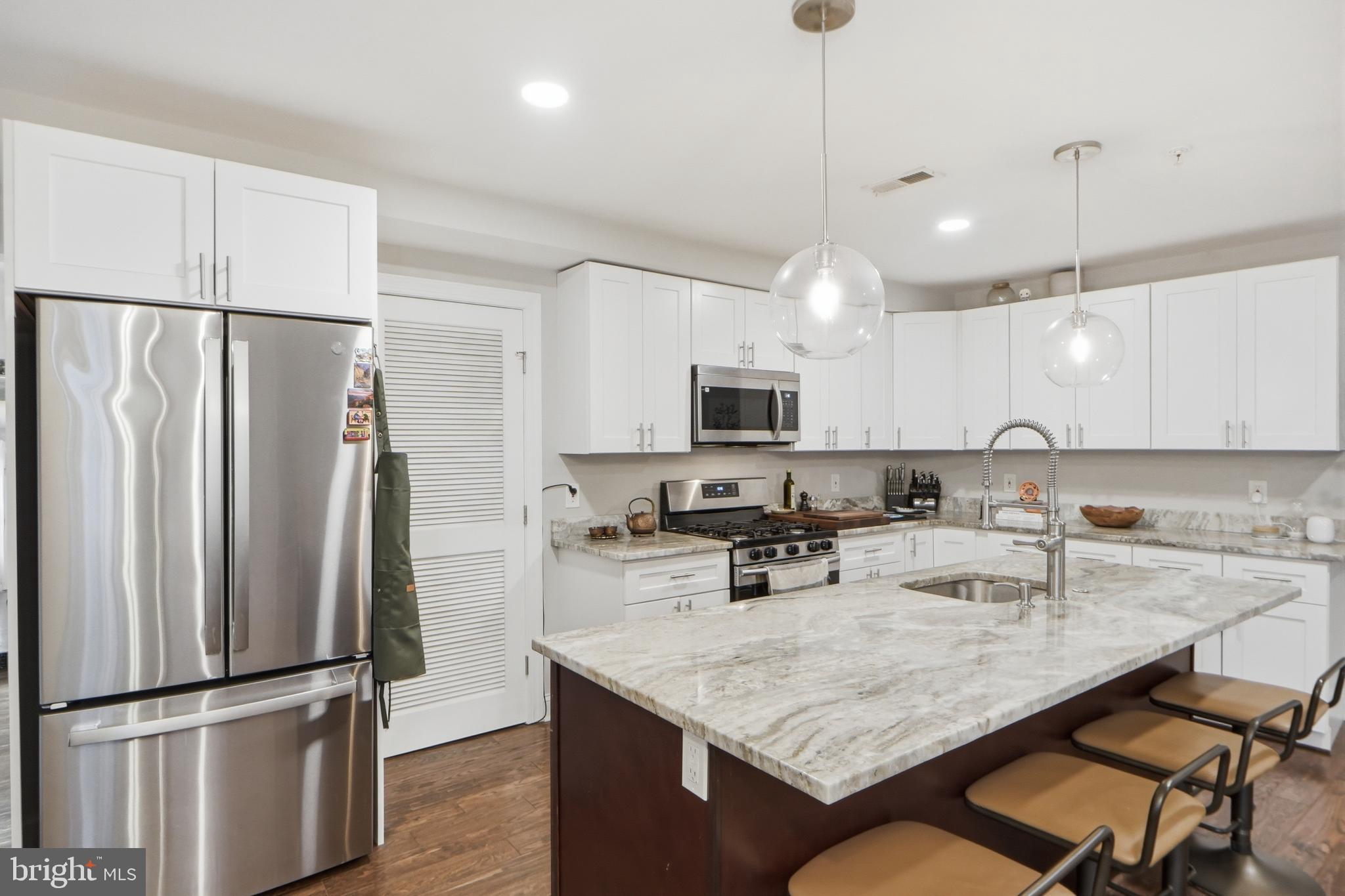 1258 Holbrook Terrace Northeast, Unit 5 Washington, DC 20002 - Photo 9 of 25 a kitchen with stainless steel appliances granite countertop a sink refrigerator and microwave