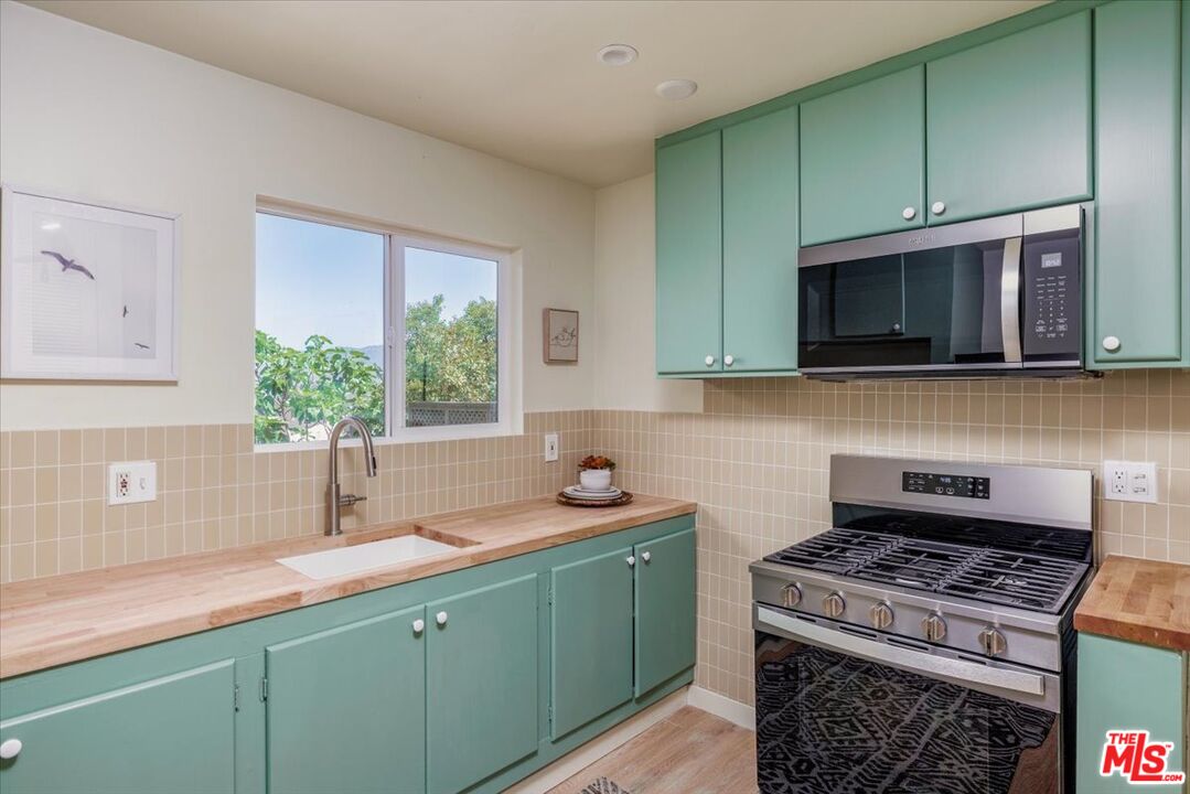 2467 Silver Ridge Avenue Los Angeles, CA 90039 - Photo 25 of 42 a kitchen with stainless steel appliances granite countertop a sink stove and microwave