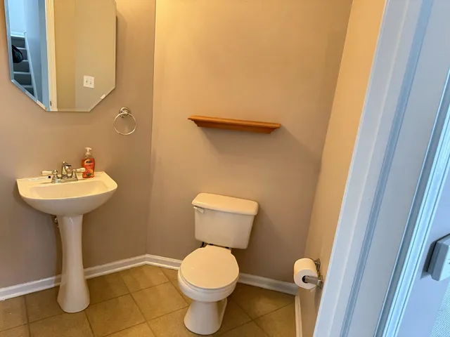 a bathroom with a sink toilet and a mirror