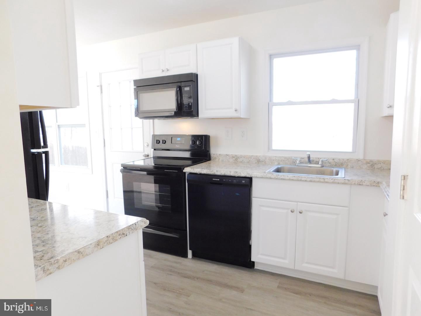 151 West Rutherford Drive Newark, DE 19713 - Photo 4 of 6 a kitchen with granite countertop a refrigerator stove and microwave