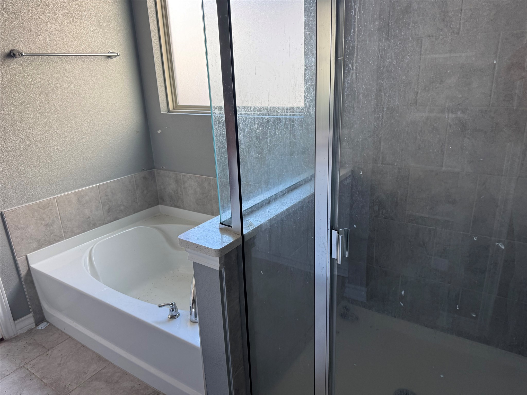 333 Capstone Road Liberty Hill, TX 78642 - Photo 23 of 40 Bathroom featuring a textured wall, a garden tub, and a stall shower