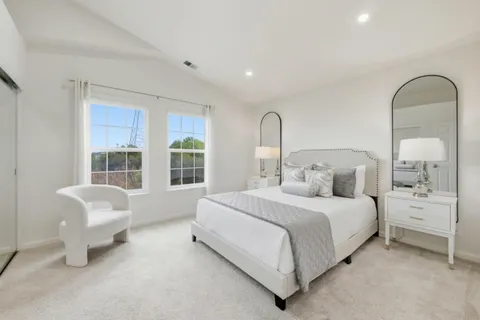 a bedroom with a bed chair and window