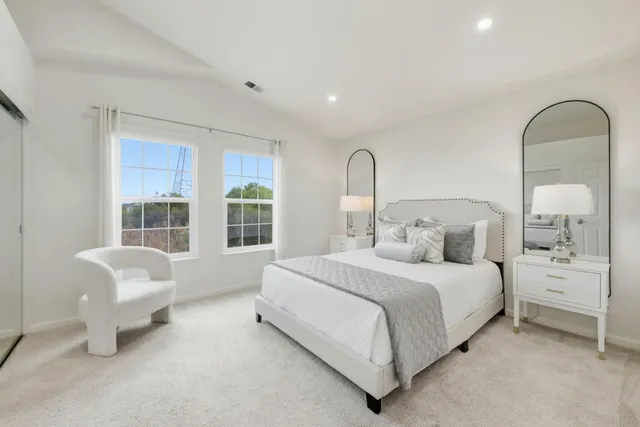 a bedroom with a bed chair and window