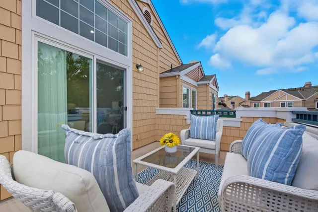 a view of a patio with couches chairs and wooden floor