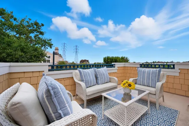 a view of roof deck with couches and sky view