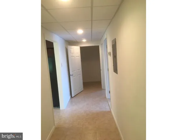 a view of an empty room with wooden floor and a painting