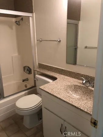 a bathroom with a granite countertop toilet sink and shower
