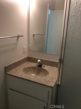 a bathroom with a granite countertop sink and a mirror