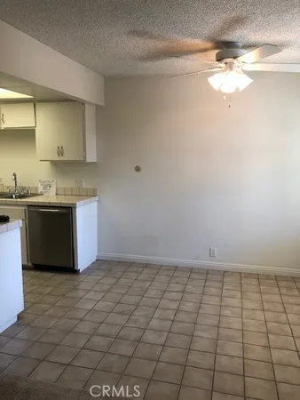 a view of kitchen with granite countertop white cabinets and a sink