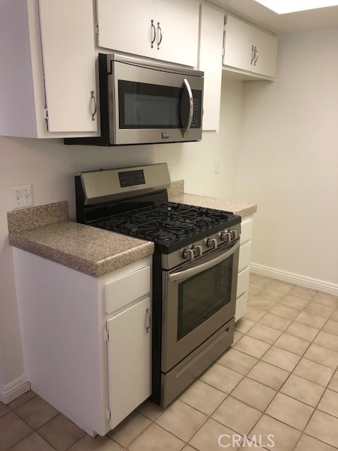 207 West Marquita, Unit 6 San Clemente, CA 92672 - Photo 8 of 15 a kitchen with granite countertop white cabinets and stainless steel appliances