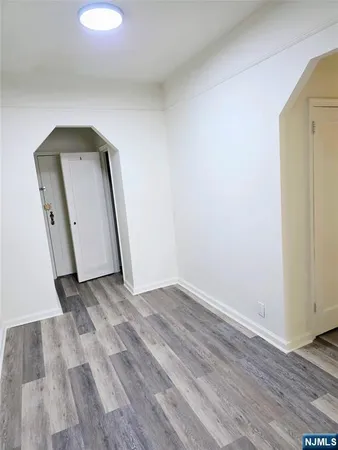 an empty room with wooden floor and mirror