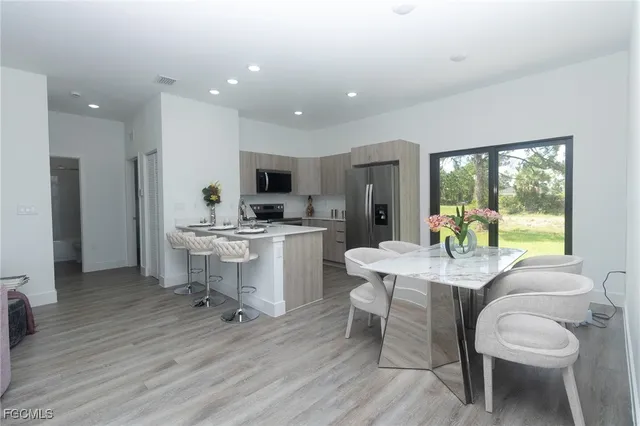 a kitchen with a table chairs refrigerator and cabinets