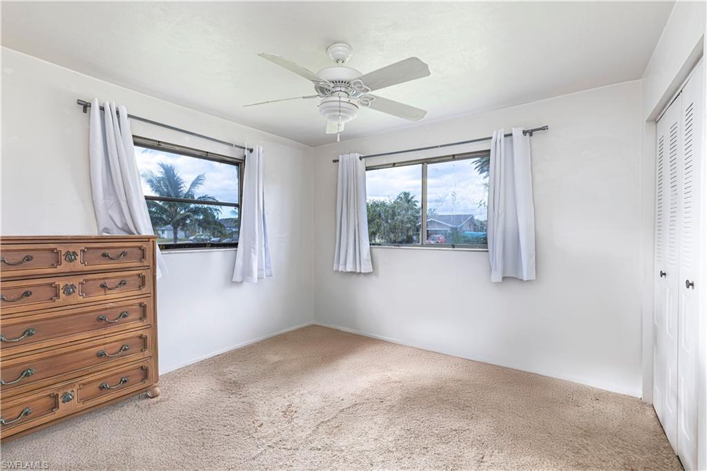4484 30th Place Southwest Naples, FL 34116 - Photo 11 of 20 Unfurnished bedroom with carpet flooring, a closet, and a ceiling fan