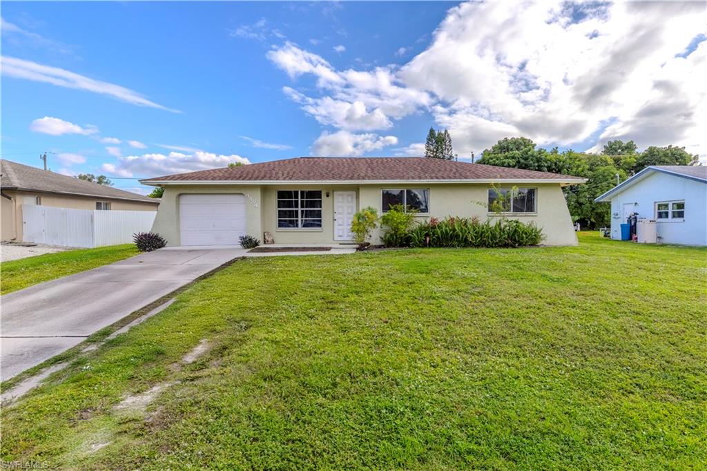 4484 30th Place Southwest Naples, FL 34116 - Photo 2 of 20 Ranch-style home featuring stucco siding, concrete driveway, and a garage