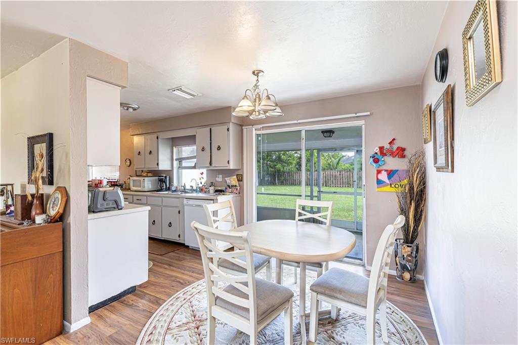 4484 30th Place Southwest Naples, FL 34116 - Photo 5 of 20 Dining area featuring wood finished floors and a chandelier