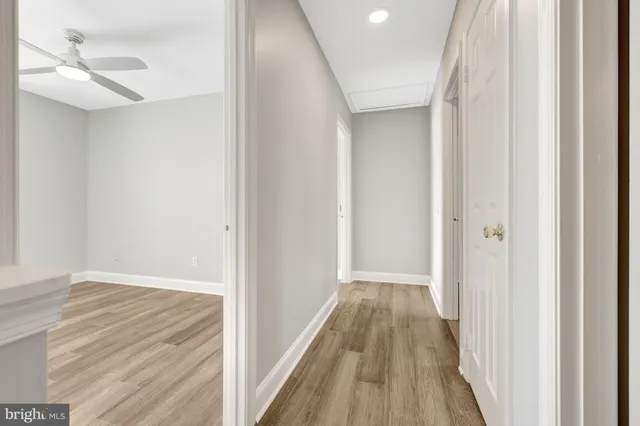 a view of a hallway with wooden floor and a chandelier