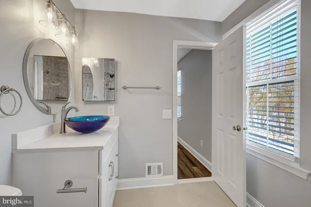 a bathroom with a granite countertop sink and a mirror