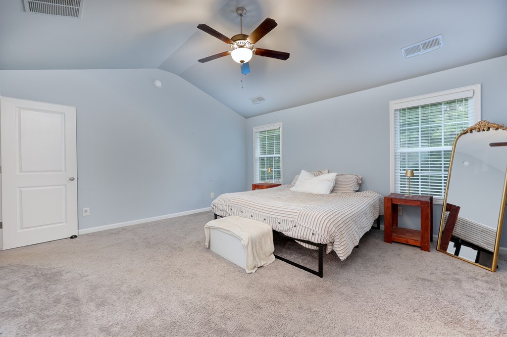 98 Valley Bluff Drive Hamilton, GA 31811 - Photo 17 of 35 a spacious bedroom with a bed and a chair