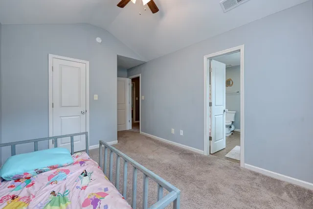 a bathroom with a granite countertop sink a toilet a mirror and shower curtain