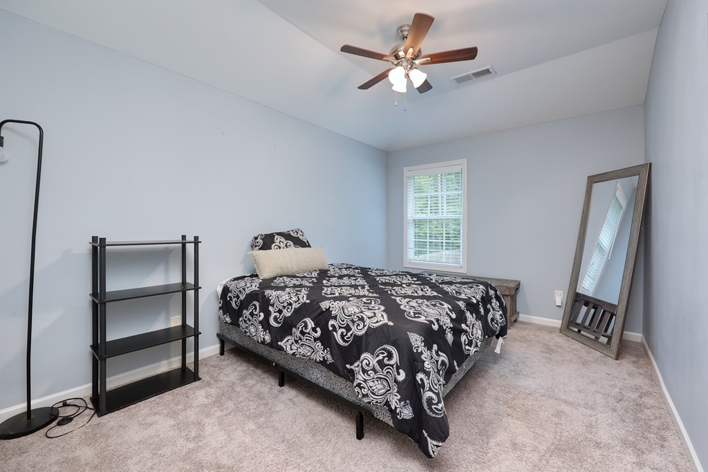 98 Valley Bluff Drive Hamilton, GA 31811 - Photo 28 of 35 a bedroom with a bed and a chandelier