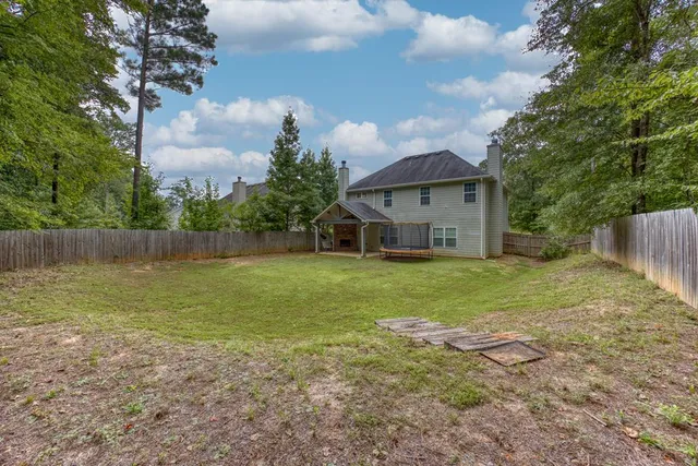 a view of house with backyard and deck