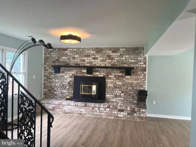 a kitchen with a fireplace and wooden floor