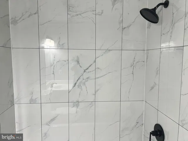 en empty room with a chandelier fan and wooden floor