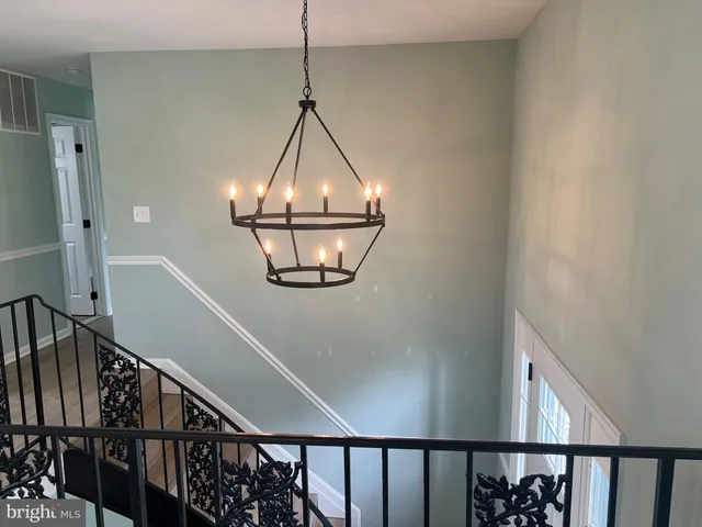 a view of a hallway with wooden floor and stairs