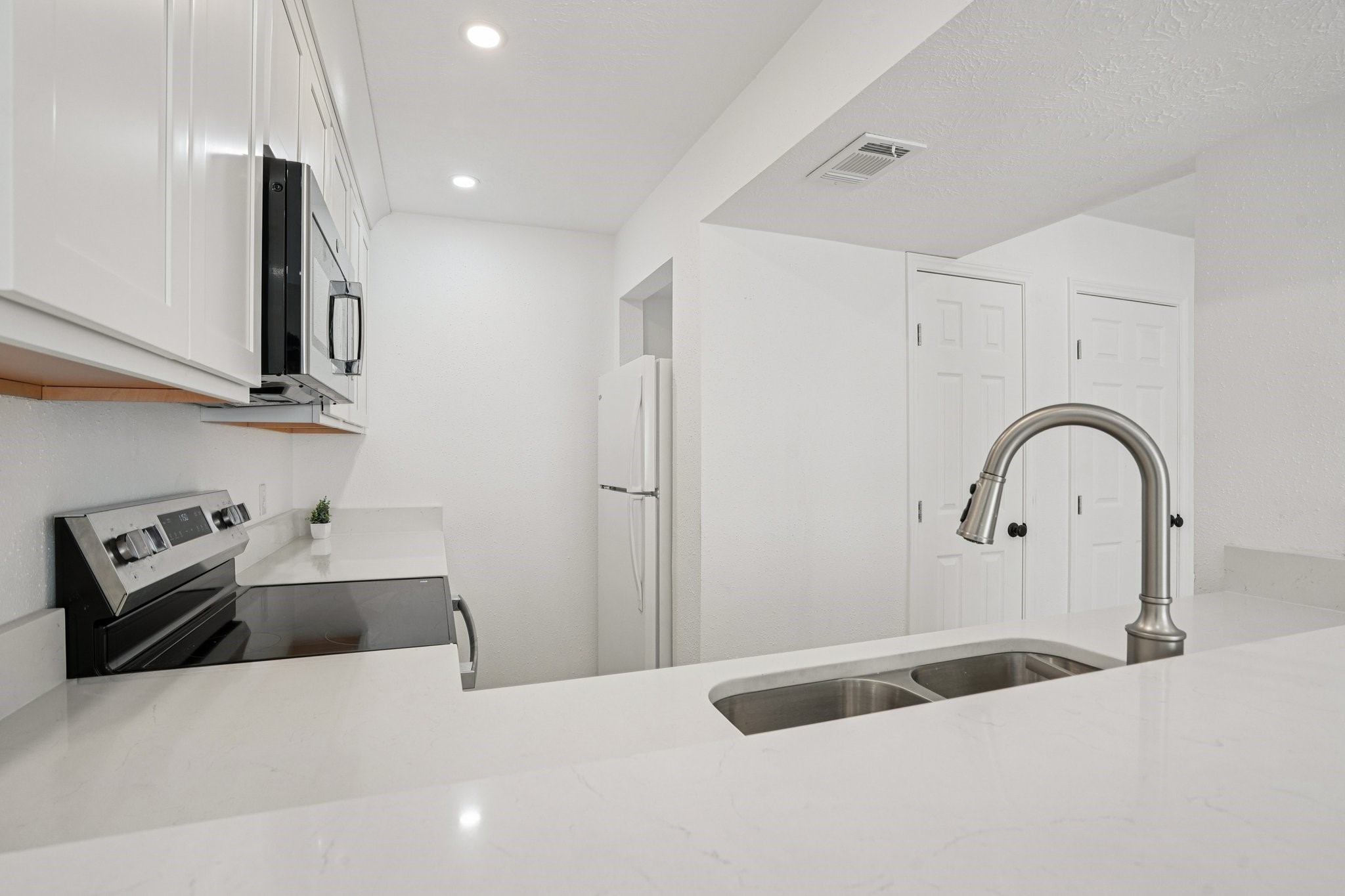 2800 Jeanetta Street, Unit 203 Houston, TX 77063 - Photo 9 of 28 a kitchen with stainless steel appliances a sink a stove and a refrigerator