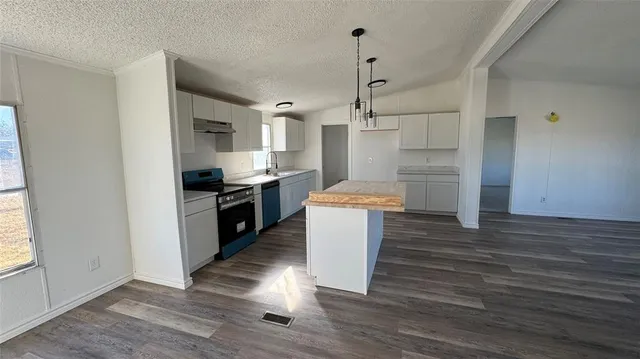 a kitchen with granite countertop a stove and a refrigerator
