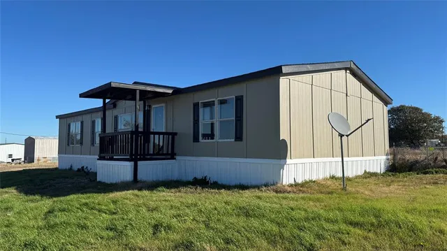 a backyard of a house with table and chairs