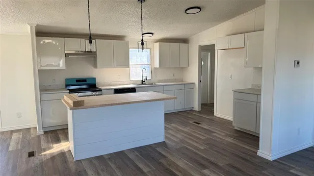 a kitchen with kitchen island a sink and a refrigerator