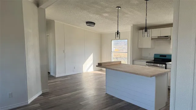 a kitchen with kitchen island a sink stove and wooden floor