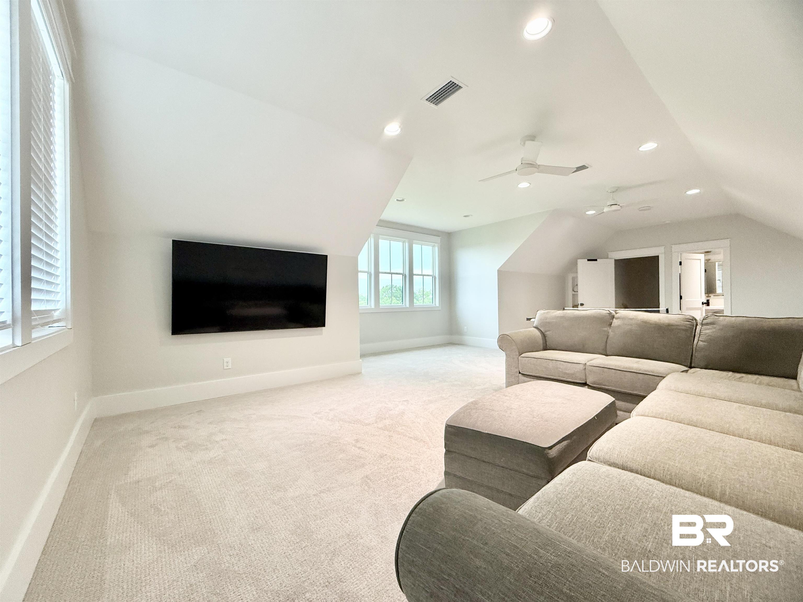 21767 Gallery Boulevard Fairhope, AL 36532 - Photo 49 of 74 Living area featuring light colored carpet, vaulted ceiling, recessed lighting, and a ceiling fan