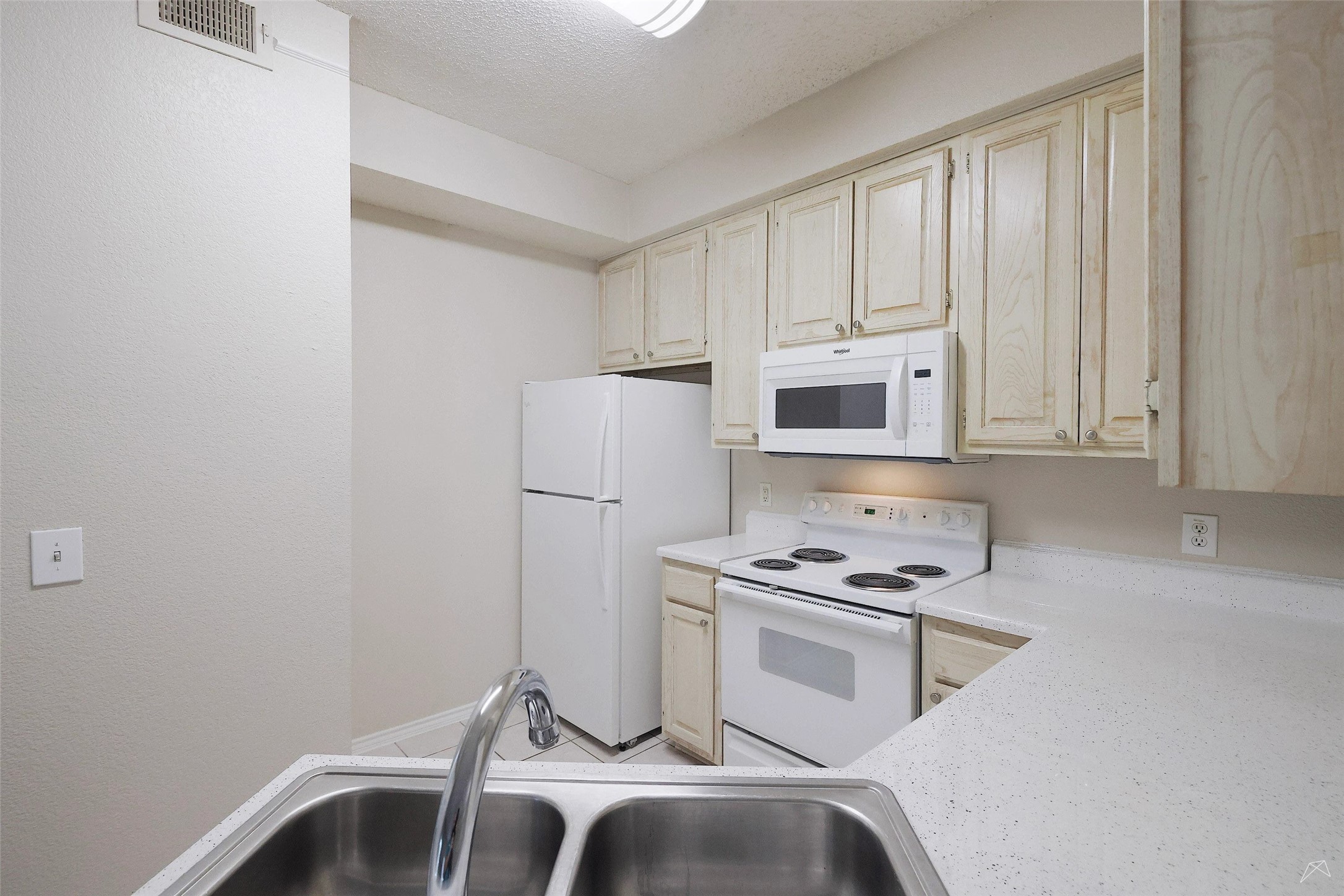 11908 Anderson Mill Road, Unit 331 Cedar Park, TX 78613 - Photo 4 of 24 a kitchen with a refrigerator and white cabinets