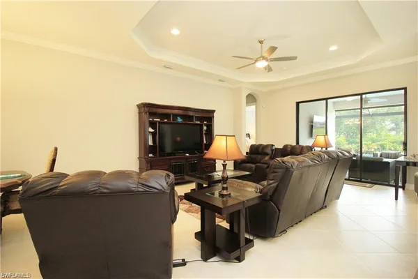 a living room with furniture a large window and a chandelier