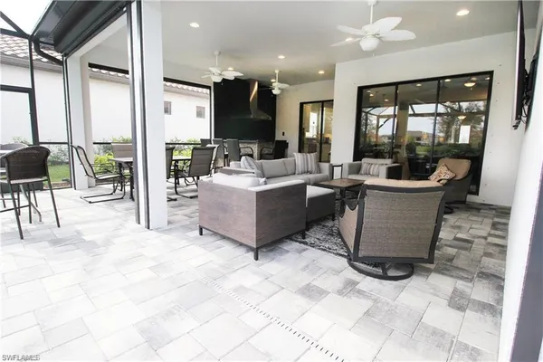 a living room with couches and kitchen view with wooden floor